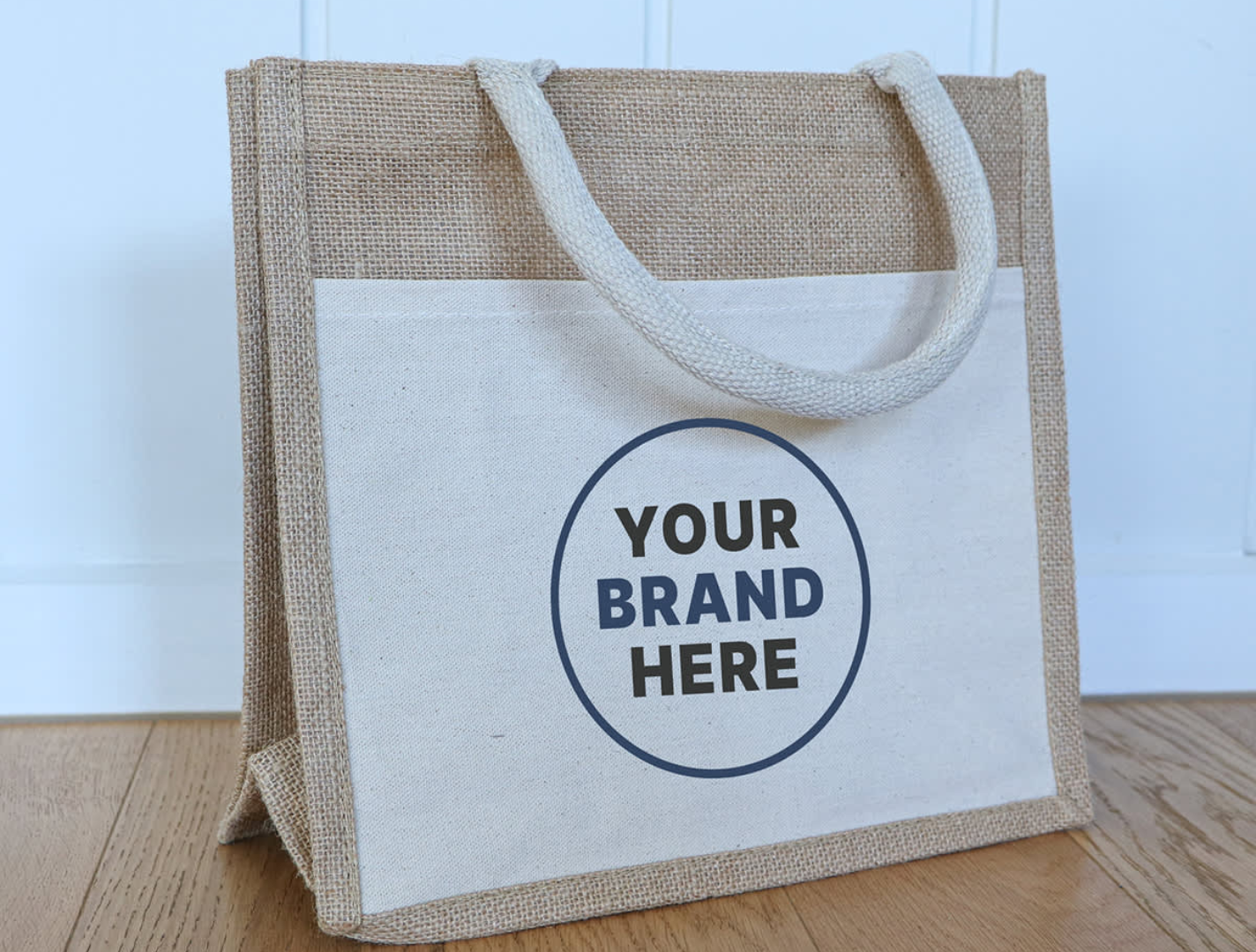 A jute tote bag featuring a natural brown colour with a cream panel and a logo area for branding.