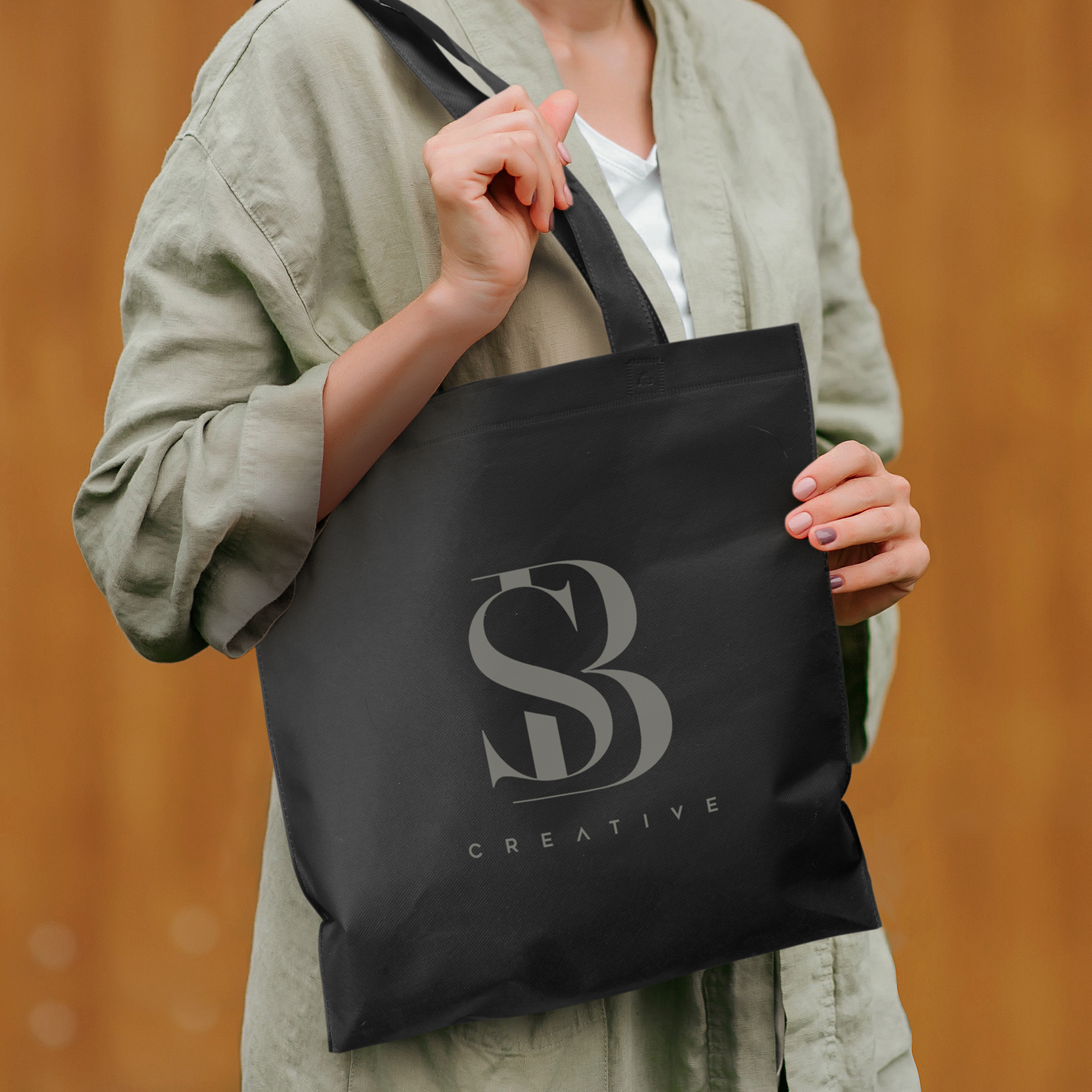 A black tote bag with two handles and a plain design. The bag includes a logo.